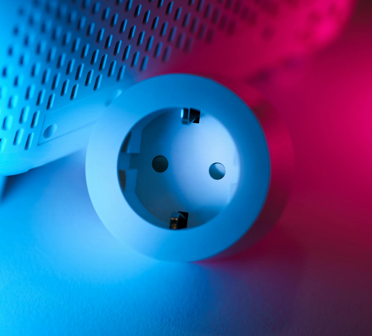 Close-up of a smart socket with vibrant blue and pink neon lighting, showcasing modern technology.